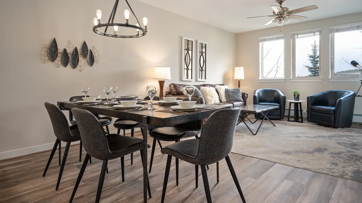 A welcoming interior with a dining table set for a meal, comfortable seating area, and decorative wall art. The mood is warm and festive, suggesting an environment perfect for entertaining, family meals, or intimate gatherings.